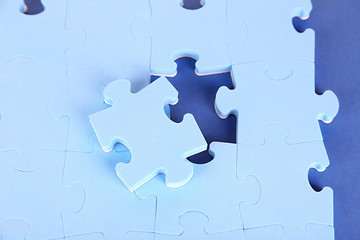 Obraz premium Last piece of jigsaw puzzle, close-up, on blue background