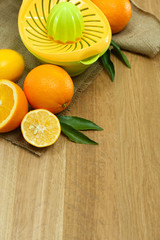 Citrus press and fruits on wooden background