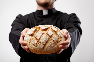 Priest holding loaf of bread