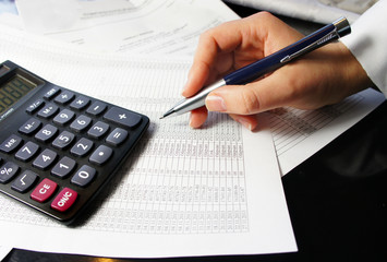 Office table with calculator, pen and accounting document