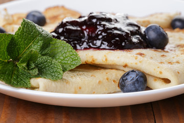 homemade blinis or crepes with blueberries and jam