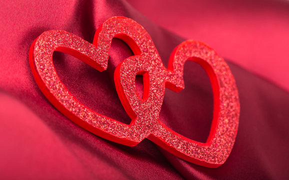 Red hearts over silk red background