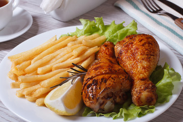 fried chicken drumsticks with french fries, rosemary and lemon