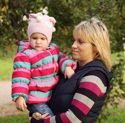 Happy mum with a daughter in autumn park