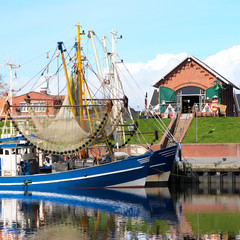 Crabber boat and Cafe in Greetsiel harbor - northern if Germany