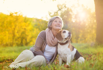 Active senior woman hugs dog