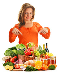 Young woman with variety of grocery products isolated on white