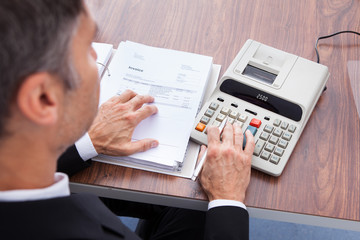 Businessman Calculating Invoice