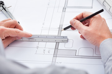 Architect Drawing On Blueprint