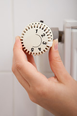 Person Adjusting Temperature By Thermostat