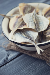 Close-up of an enameled bowl with dried scad, vertical shot