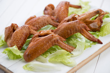 Smoked chicken wings with salad leaves, horizontal shot