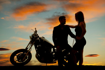 Fototapeta na wymiar silhouette of woman by man on motorcycle