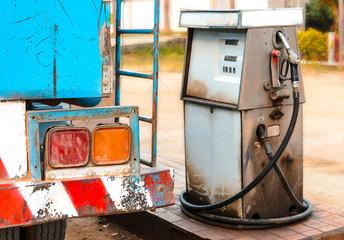 old dirty gas station pump with fuel truck