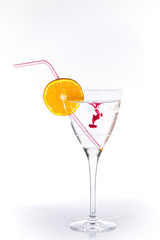 Verre rempli d'eau dans lequel on dilue du colorant alimentaire