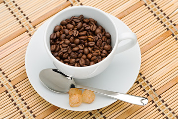 cup with a spoon and sugar with coffee beans