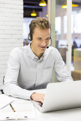 Businessman in the office on the phone with headset, Skype