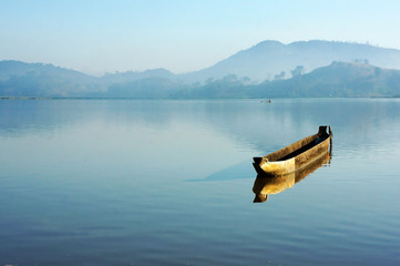Plakaty  Charming landscape with lonely wooden boat (dug-out canoe ) on l