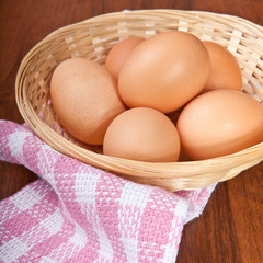 Chicken eggs in a wicker basket on the table