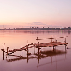 Tranquil sunset with a jetty on Mekong river in autumn.