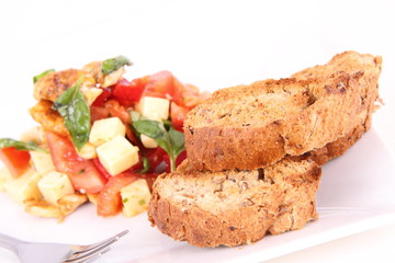 Chicken, cheese & vegetable salad with some bread on a plat
