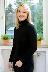 Freundliche blonde Frau vor Fenster