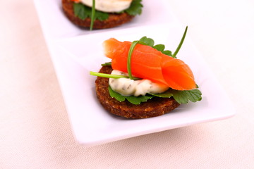 Smoked salmon roll on pumpernickel bread with remoulade