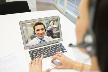 Fototapeta na wymiar Businesswoman in the office on videoconference, headset, Skype
