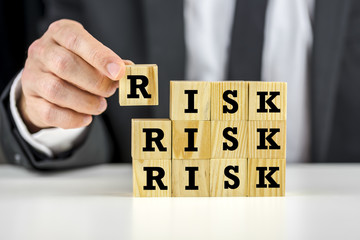 Naklejka premium Man stacking wooden risk blocks