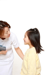 子供の患者に話しかける女性看護師