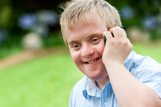 Handicapped boy talking on cell phone.
