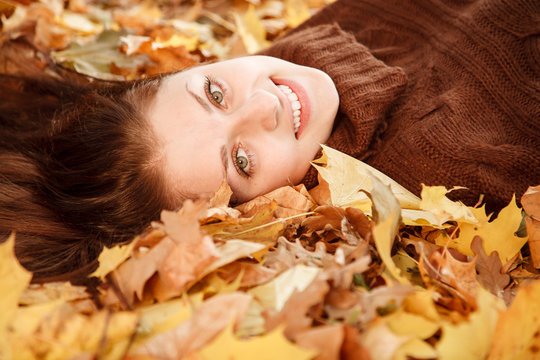 teenage girl lying down on leaves