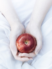 Red apple in the woman's hands