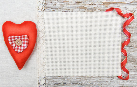 Valentine background  with textile heart and ribbon on old wood