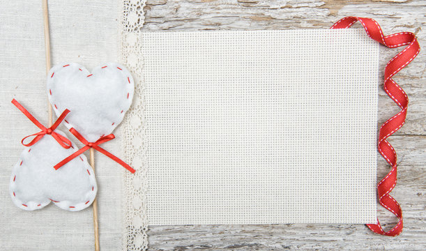 Valentine background  with textile hearts and ribbon on old wood