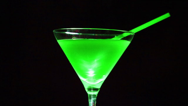 Green  cocktail. Wine  glass in rotation