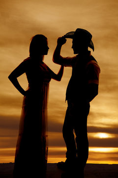 cowboy couple stand silhouette his hand on hat