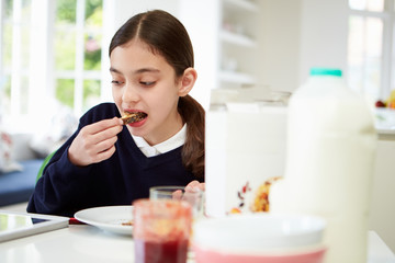 Schoolgirl With Digital Tablet And Mobile Eating Toast - obrazy, fototapety, plakaty