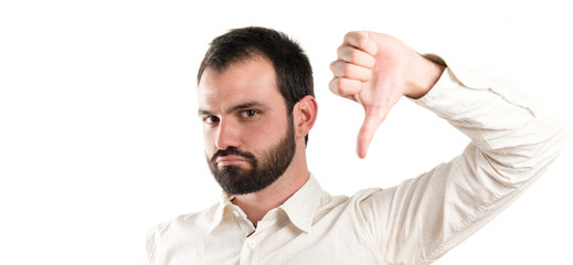 Young man with thumbs down over white background
