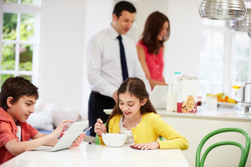 Obraz na płótnie Canvas Family Using Digital Devices At Breakfast Table