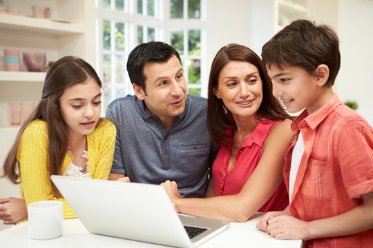 Family Looking At Laptop Over Breakfast