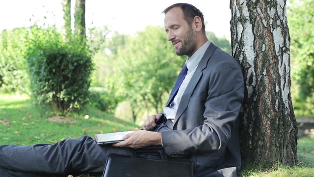 businessman finishing work on his laptop  and smiling to the cam