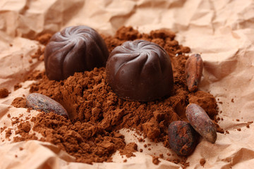 Composition of chocolate sweets and cocoa on brown background