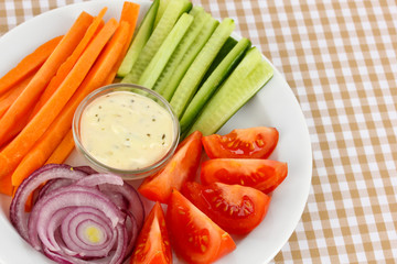Assorted raw vegetables sticks in plate on table close up