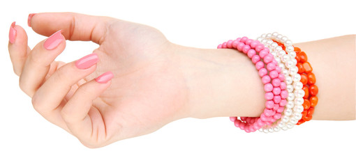 Female hand with pink manicure and bright bracelets, isolated