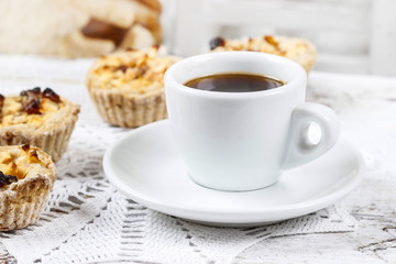 Cup of coffee and small cakes with dried fruits on wooden rustic