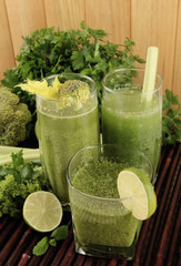 Glasses of green vegetable juice and vegetables