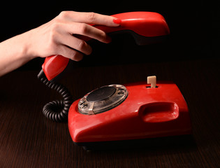 Red retro telephone,on dark background