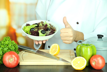 Cook hands holding plate of salad