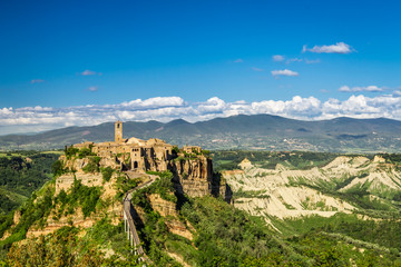 Fototapeta premium Ancient city on hill in Tuscany on a mountains background.
